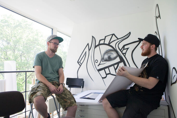 Studierende des Studiengangs Design diskutieren Posterentwürfe.