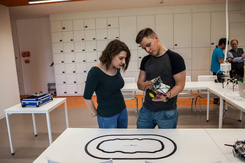 zwei Menschen mit selbstfahrendem Roboter und Teststrecke