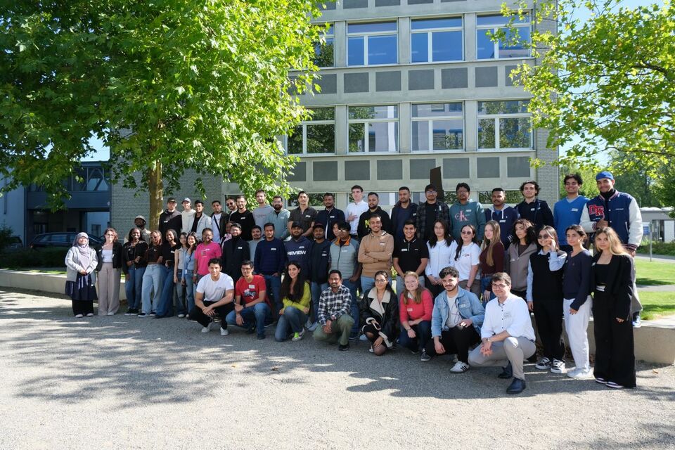 Eine Gruppe internationaler Studierender kommt für ein Gruppenbild auf dem Campus Krefeld-Süd zusammen. Bild: Nina Maria Kohl