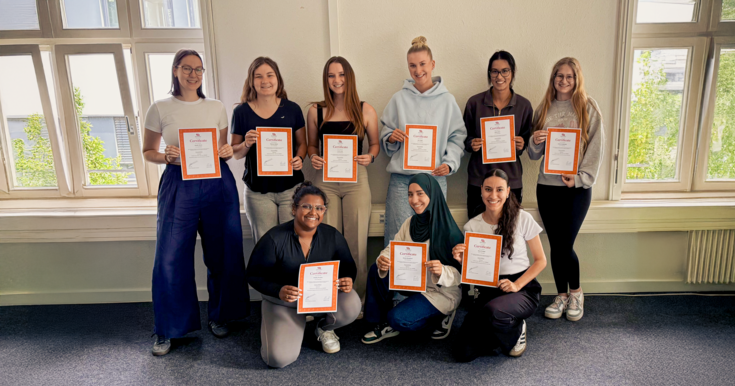 Gruppenfoto Studierende B.A. Kindheitspädagogik mit Zertifikat mit DIN A4 Blatt
