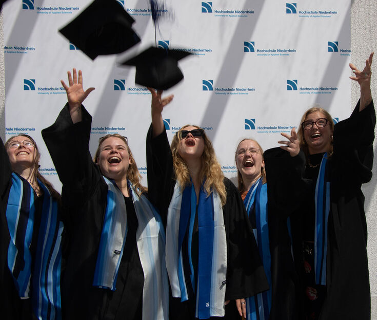 Absolventinnen in Talaren feiern Abschluss