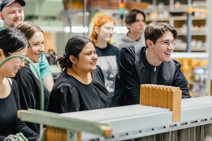 Studierende des Fachbereichs Textil- und Bekleidungstechnik arbeiten an einer Webmaschine