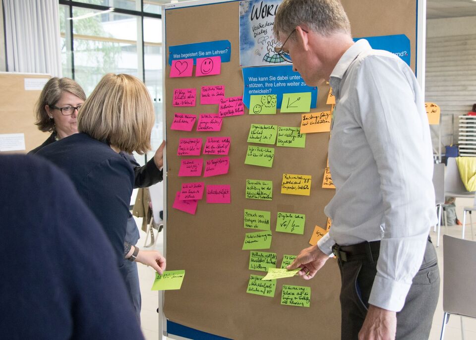 Menschen vor Pinnwand mit Post-its